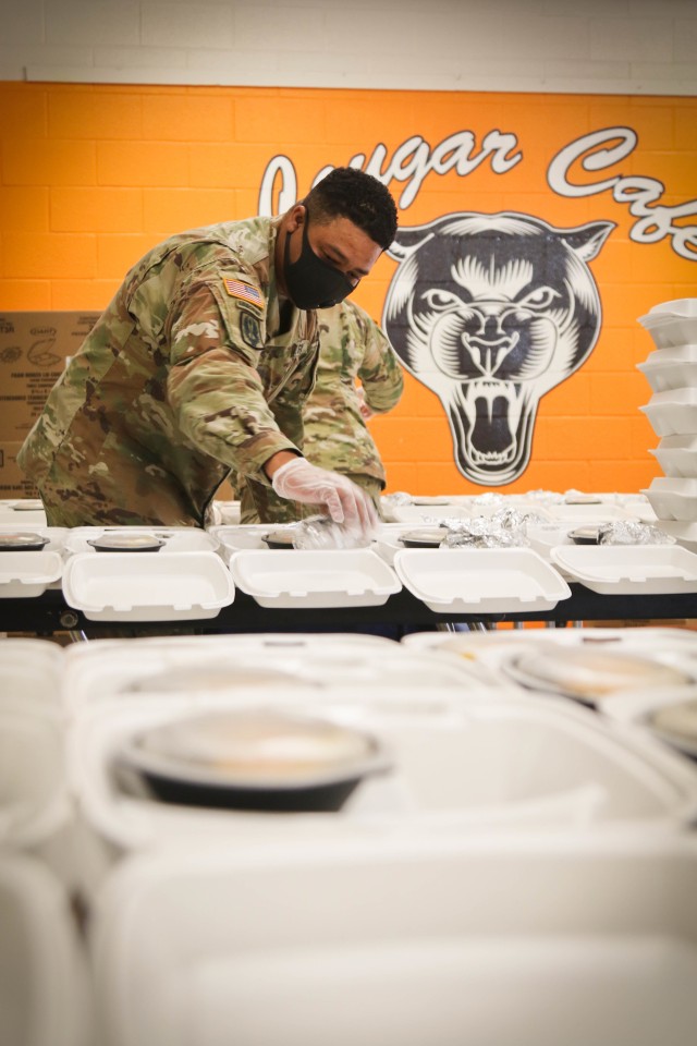 Sgt. Darian Fleming, assigned to the 449th Theatre Aviation Brigade, places food into individual trays to distribute to the citizens of Bladen County at the Elizabethtown Middle School in Bladen County, N.C., May 26, 2020. The NCNG is working with North Carolina Emergency Management, N.C. Department of Health and Human Services and local food banks to help support COVID-19 relief efforts. (U.S. Army National Guard photo by Spc. Hannah Tarkelly, 382nd Public Affairs Detachment/Released).