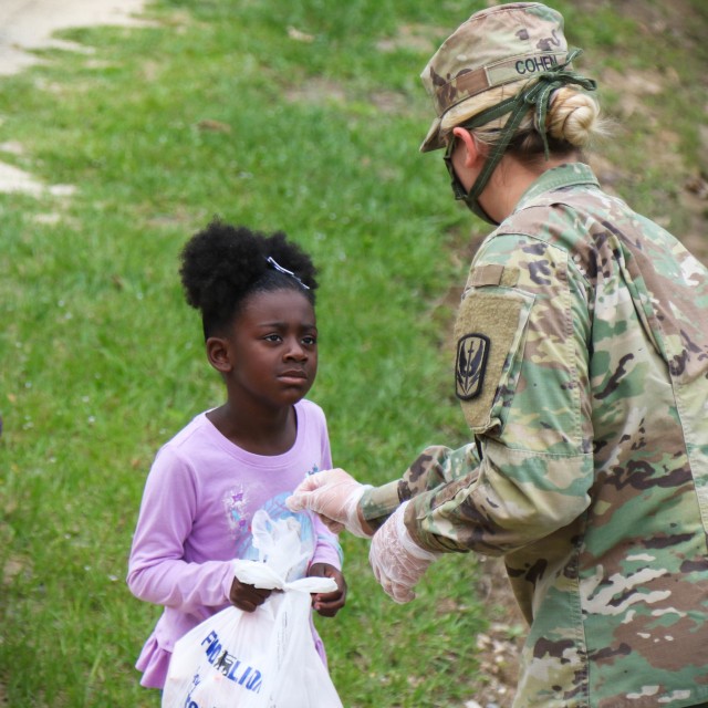 Spc. Amber Cohen, assigned to the 449th Theatre Aviation Brigade, distributes meals, prepared at the ElizabethTown Middle School, to the citizens in Bladen County, N.C., May 26, 2020. The NCNG is working with North Carolina Emergency Management, N.C. Department of Health and Human Services and local food banks to help support COVID-19 relief efforts. (U.S. Army National Guard photo by Spc. Hannah Tarkelly, 382nd Public Affairs Detachment/Released).