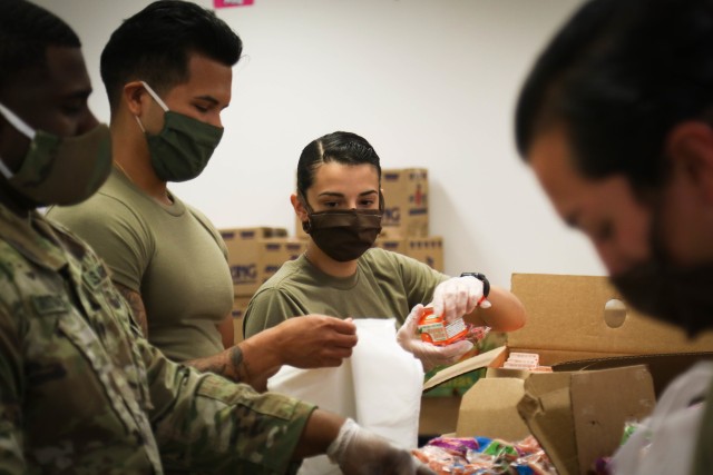 Spc. Priscilla Gonzalo, assigned to the 449th Theatre Aviation Brigade, the places breakfast food into a bag for future distribution in an assembly line at the Elizabethtown Middle School in Bladen County, N.C., May 26, 2020. The NCNG is working with North Carolina Emergency Management, N.C. Department of Health and Human Services and local food banks to help support COVID-19 relief efforts. (U.S. Army National Guard photo by Spc. Hannah Tarkelly, 382nd Public Affairs Detachment/Released).