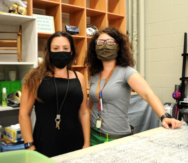 Jasmin Morrow, manager (left), is pictured with the outgoing manager, Martina Piazzon (right), at the front counter of the Fort Polk Thrift Shop, adhering to COVID-19 facial-covering guidelines.