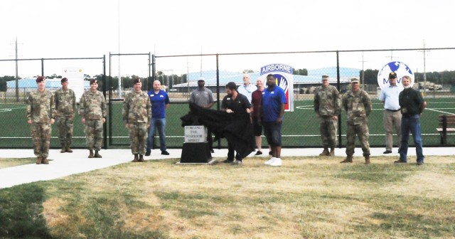 Sean McCroary, supervisory sports specialist, unveils the eighth of 10 anvil sculptures at Anvil Field June 15 as Fort Polk command and representatives from Morale, Welfare and Recreation, G3 and sports, fitness and aquatics leadership look on.