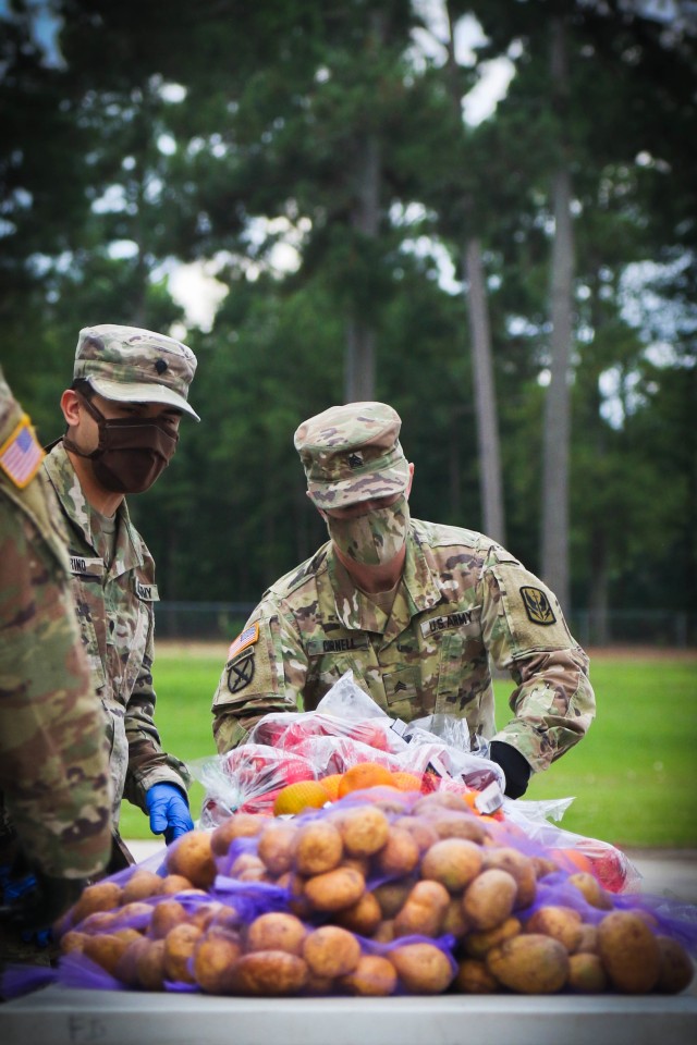 North Carolina Army National Guard Sgt. Timothy Cornell (right), assigned to 2-130th Airfield Operations Battalion, sorts produce while working alongside volunteers from Team Rubicon, a veteran disaster relief service organization, Action Pathways, a non-profit organization, and the Second Harvest Food Bank Southeast to distribute food to approximately 250 families at the Midway Elementary School in Dunn, N.C., June 18, 2020. The NCNG is working with North Carolina Emergency Management, N.C. Department of Health and Human Services and local food banks to help support COVID-19 relief efforts. (North Carolina Army National Guard photo by Spc. Hannah Tarkelly, 382nd Public Affairs Detachment/Released).