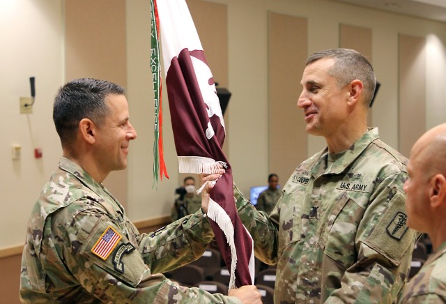 Lt. Col. Marc R. Welde, left, outgoing commander of the U.S. Army Medical Materiel Center-Korea, passes the colors to Col. Derek C. Cooper to relinquish command during a Change of Command ceremony on June 18 at Camp Carroll. Cooper served as the stand in for Col. Michael Lalor, commander of Army Medical Logistics Command, during the ceremony.