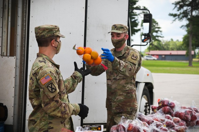 North Carolina Army National Guard Sgt. Timothy Cornell (left) and Spc. William Best, assigned to 2-130th Airfield Operations Battalion, move produce alongside volunteers from Team Rubicon, a veteran disaster relief service organization, Action...