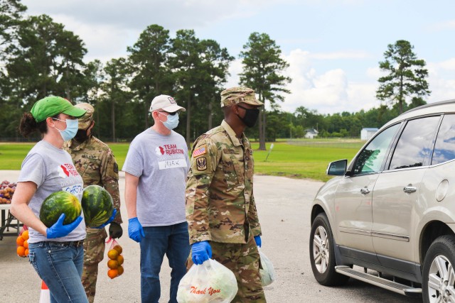 North Carolina Army National Guard Soldiers of the 449th Theater Aviation Brigade work alongside volunteers from Team Rubicon, a veteran disaster relief service organization, Action Pathways, a non-profit organization, and the Second Harvest Food...