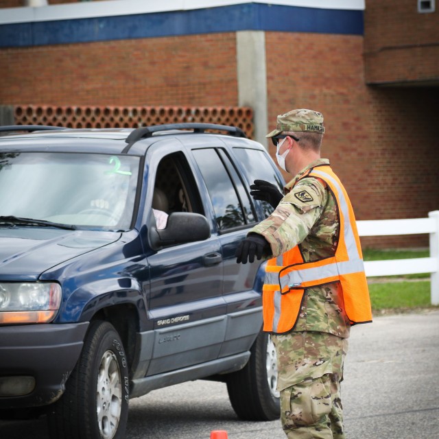 North Carolina Army National Guard Sgt. David Hamilton, assigned to the 1-130th Attack Reconnaissance Battalion, guides a vehicle forward while working alongside volunteers from Team Rubicon, a veteran disaster relief service organization, Action...