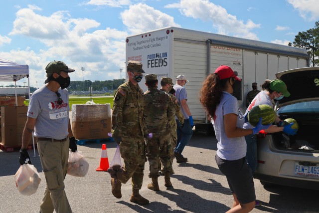 North Carolina Army National Guard Soldiers of the 449th Theater Aviation Brigade work alongside volunteers from Team Rubicon, a veteran disaster relief service organization, Action Pathways, a non-profit organization, and the Second Harvest Food Bank Southeast to distribute food to approximately 250 families at the Midway Elementary School in Dunn, N.C., June 18, 2020. The NCNG is working with North Carolina Emergency Management, N.C. Department of Health and Human Services and local food banks to help support COVID-19 relief efforts. (North Carolina Army National Guard photo by Spc. Hannah Tarkelly, 382nd Public Affairs Detachment/Released).