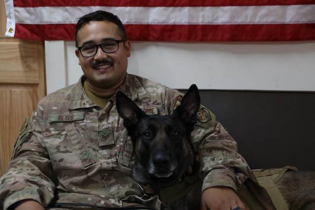 U.S. Air Force Staff Sgt. Juan Reyes sits with his Military Working Dog partner Cvoky in Kuwait on June 16, 2020. The team visited Kuwait to seek treatment after Cvoky suffered a heat injury. ( U.S. Army National Guard photo by Trevor Cullen)
