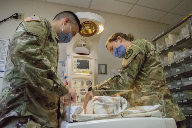 Army Capt. Mateo Betancourt and Army Capt. Elizabeth Koslow simulate checking on a swaddled infant in the Pediatrics ward at Brooke Army Medical Center. Both doctors completed their residency and graduated from the San Antonio Uniformed Services Health Education Consortium in June. (U.S. Army Photo by Daniel J. Calderón)