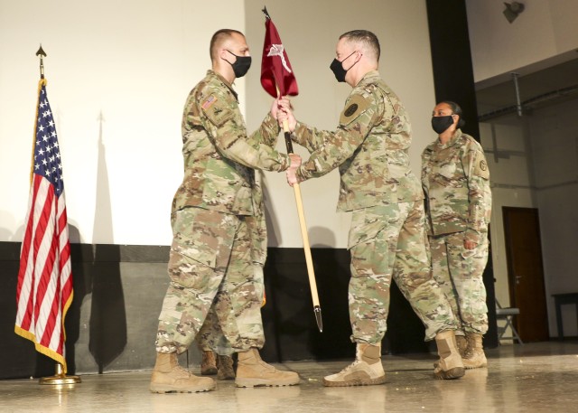 Lt. Col. James McWherter (left), incoming commander, Wiesbaden Army Health Clinic, receives the unit guidon from Col. Michael Weber, commander, Landstuhl Regional Medical Center, during a change of command and responsibility ceremony, June 12.