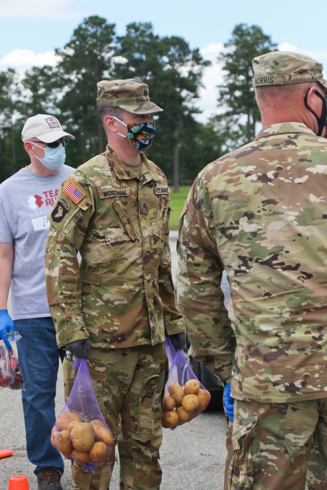 North Carolina Army National Guard Sgt. Bruce Wortham, assigned to the 1-130th Attack Reconnaissance Battalion, places food into a vehicle alongside volunteers from Team Rubicon, a veteran disaster relief service organization, Action Pathways, a...