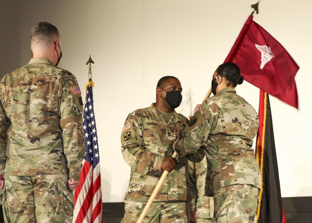 Sgt. 1st Class Timothy Johnson (center), detachment sergeant, Wiesbaden Army Health Clinic, passes the unit guidon to Col. Stacy Freeman, outgoing commander, WAHC during a change of command and responsibility ceremony, June 12.