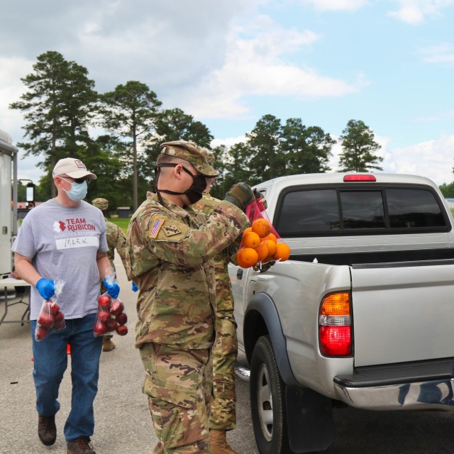 North Carolina Army National Guard Sgt. 1st Class Jason Norris, assigned to the 1-130th Attack Reconnaissance Battalion, places food into a vehicle alongside volunteers from Team Rubicon, a veteran disaster relief service organization, Action...