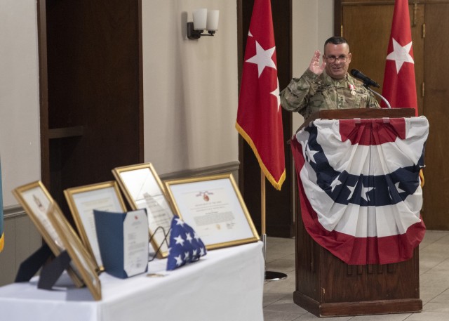 With the awards and certificates presented to him and his wife, Mary, in the foreground, Maj. Gen. Steven A. Shapiro speaks during his retirement ceremony, held June 24 at Rock Island Arsenal, Illinois.  In emotional remarks, Shapiro praised his wife as “captain of Team Shapiro” and thanked the many people who supported and mentored him during his 35-year career.