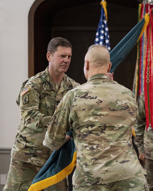 Maj. Gen. Daniel G. Mitchell, incoming commanding general of ASC, receives the flag of command from Lt. Gen. Thomas S. James, commanding general of First Army, during a change of command ceremony held June 24 at Rock Island Arsenal, Illinois.  James was acting as a proxy for Gen. Gus Perna, commanding general of the U.S. Army Command, who presided over the ceremony via live video link.