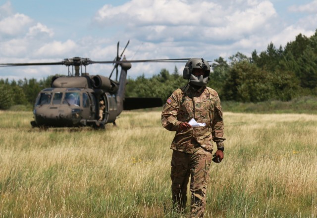 Staff Sgt. Christopher Abrom, a member of Charlie Company, 1st of the 158th Assault Helicopter Battalion prepares to certify a high mobility multipurpose wheeled vehicle (HMMWV) for sling load operations during Northern Strike 19 on Camp Grayling,...