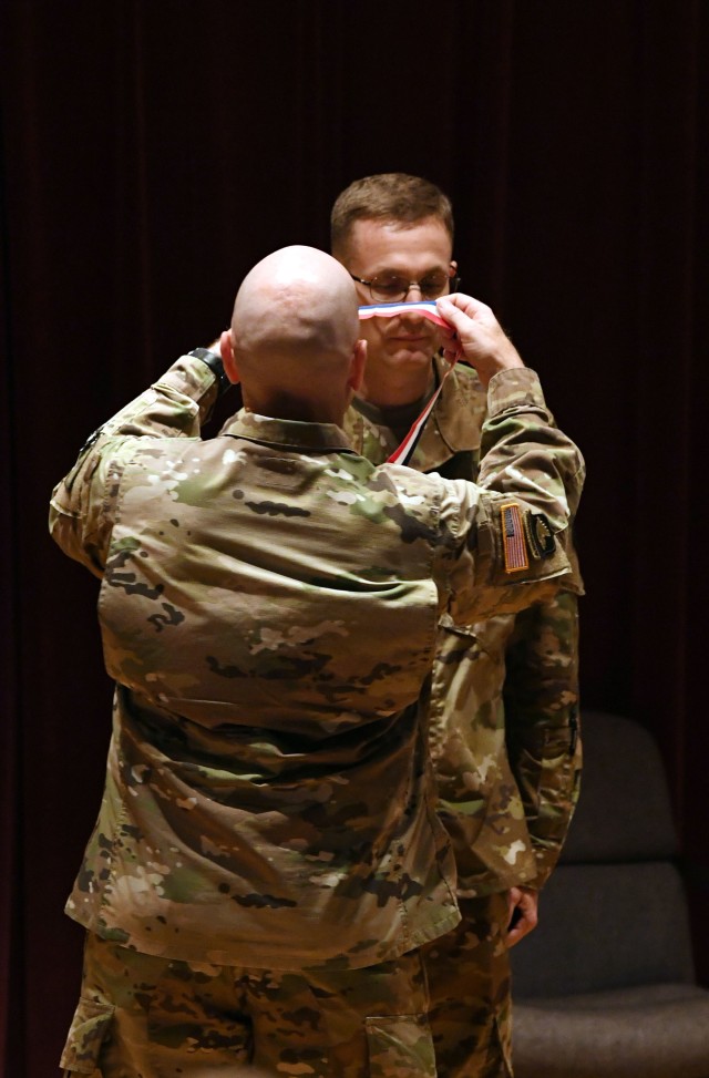 Maj. Gen. Rodney D. Fogg, commander of Combined Arms Support Command prepares to place a ribbon around the neck of Col. Michael McTigue before a change of command ceremony June 23.