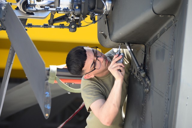 U.S. Army Pfc. Antonio Montes assigned to Company B, 1st Battalion, 3rd Aviation Regiment (Attack Reconnaissance) conducts maintenance on an AH-64 Apache helicopter at Katterbach Army Airfield, Germany, June 24, 2020. (U.S. Army photo by Charles Rosemond)
 