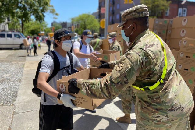 U.S. Army Pfc. Kristoffshakur Larmond, assigned to the 1st Battalion, 258th Field Artillery, part of the 27th Infantry Brigade Combat Team, distributes boxes of produce and various canned goods at a Brooklyn food pantry in Bushwick N.Y., May 27, 2020. Troops have helped deliver more than 16 million meals to New Yorkers experiencing food insecurity during the COVID-19 pandemic in New York City. 