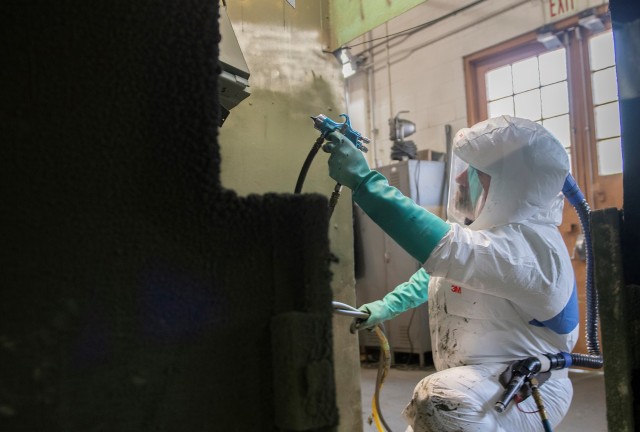 Scott House paints a reactive armor tile at Anniston Munitions Center. ANMC is repairing four variations of reactive armor tiles for combat vehicles.