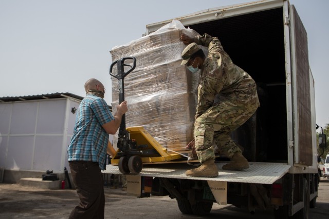 U.S. Army Maj. Robert Middleton (left), company commander, Alpha Company, 443rd Civil Affairs Battalion, Combined Joint Task Force-Horn of Africa (CJTF-HOA), and U.S. Army Staff Sgt. Mackenzie Vilme (right), team sergeant, Alpha Company, 443rd CA BN, unload hygiene supplies to assist Djibouti prevent COVID-19 infections among hospital staff and its citizens at Djibouti City, Djibouti, June 10, 2020. CJTF-HOA worked to purchase the supplies, valued at approximately $15,000, using Overseas Humanitarian, Disaster, and Civic Aid Appropriation (OHDACA) funds after the Djibouti government made a formal request for assistance to the U.S. Embassy. (U.S. Air Force photo by Senior Airman Gage Daniel)