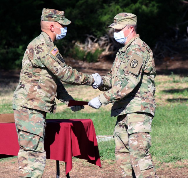 Maj. Roger Webb, a graduate of the U.S. Army Graduate Program in Anesthesia Nursing (USAGPAN), receives a diploma from Maj. Richard E. Crocker, director, USAGPAN, William Beaumont Army Medical Center, during WBAMC's 2020 GME graduation ceremony held at the North East law of the main campus, June 20. Graduates completed courses of study in residencies or internships in one of the following GME programs (DoD. photo by Vincent Byrd)