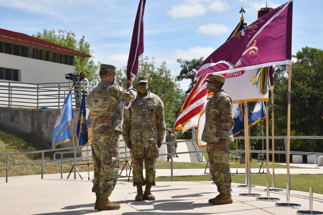 Chief of Staff of the U.S. Army, Gen. James C. McConville, passes the flag to the U.S. Army Surgeon General and Commanding General, U.S. Army Medical Command, Lt. Gen. R. Scott Dingle, in an assumption of command ceremony on Fort Sam Houston,...