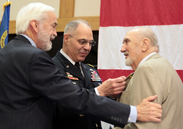 Vietnam War veteran Robert Bettencourt receives an honorary Vietnam pin from the Army Materiel Command’s Gen. Gus Perna following the program at the Armed Forces Celebration Luncheon June 28, 2017, in Huntsville, Ala. Congratulating Bettencourt is Joe Fitzgerald, North Alabama’s civilian aide to the Secretary of the Army. Bettencourt served as an Army combat medic with the 4th Infantry in Vietnam from 1969-70. (U.S. Army Photo by Sgt. Eben Boothby)