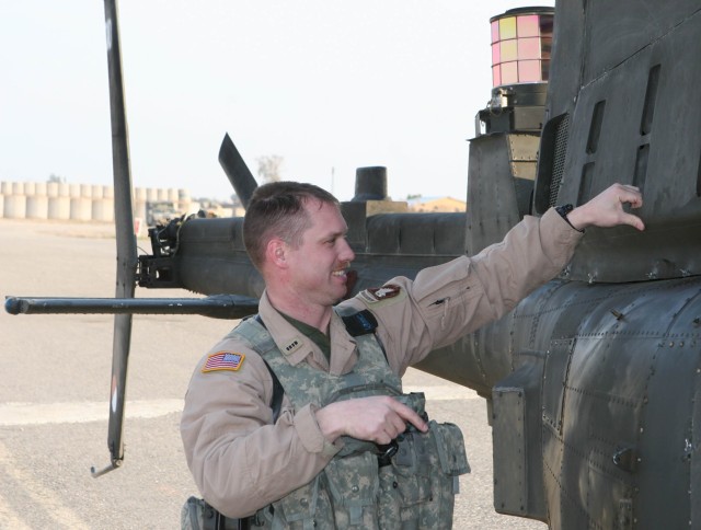 Chief Warrant Officer Brian Stoner, an OH-58D Kiowa Warrior armed reconnaissance helicopter pilot in 2nd, Squadron, 17th Cavalry Regiment, does some post-flight checks following a flight Feb. 22 on Forward Operating Base Warrior by Kirkuk, Iraq....