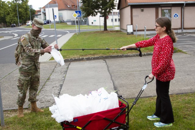 Laura Irick, a military spouse, gives away a mask to a U.S. Army Soldier June 6 on U.S. Army Garrison Wiesbaden. Irick says the masks are 100% cotton and are made in sizes large (approximately 8 1/4” x 5”), medium (approximately 6 1/4” x 4...