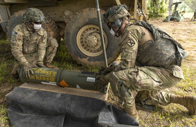 U.S. Army Sgt. Carlton Voak, a cannon crewmember assigned to Charlie Battery, 5th Battalion, 25the Field Artillery Regiment, 3rd Brigade Combat Team, 10th Mountain Division, assists another cannon crewmember with preparing a M982A1 Excalibur for a live fire event on Fort Polk, Louisiana, June 2, 2020. Observer-controller-trainers from Operations Group, Joint Readiness Training Center, supervised validation of the battery to support future live fire events. (U.S. Army photos by Staff Sgt. Ashley M. Morris)