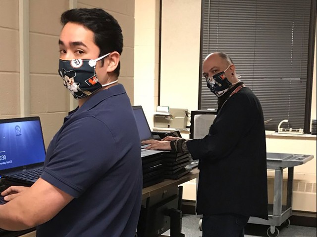 Billy Breeden (left) and Christian Gierak (right), Tank-automotive and Armaments Command Desktop Support-G6, practice social distancing and the wear of cloth face coverings while working on laptops at the Detroit Arsenal. The Centers for Disease...