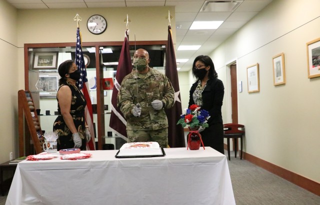 Brig. Gen. Shan K Bagby, Brooke Army Medical Center Commanding General, inspects the saber before cutting a cake during a ceremony with staff, celebrating his assumption of command, June 26, 2020. His wife Melanie, left, and daughter Sydney, far...