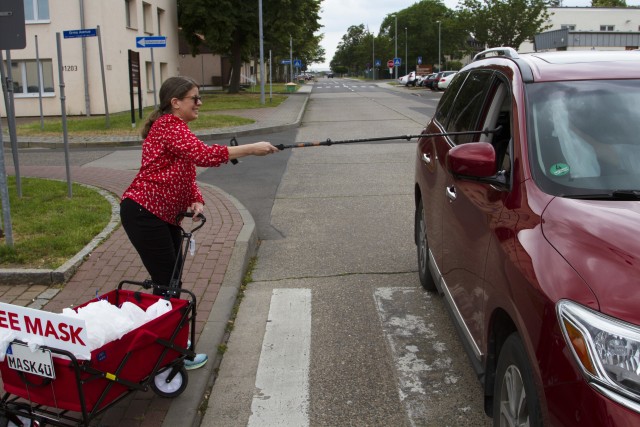 Laura Irick, a military spouse, gives away a mask June 6 at U.S. Army Garrison Wiesbaden. Irick can be spotted on her routine delivery runs with a red wagon that reads “Mask4U” on post.