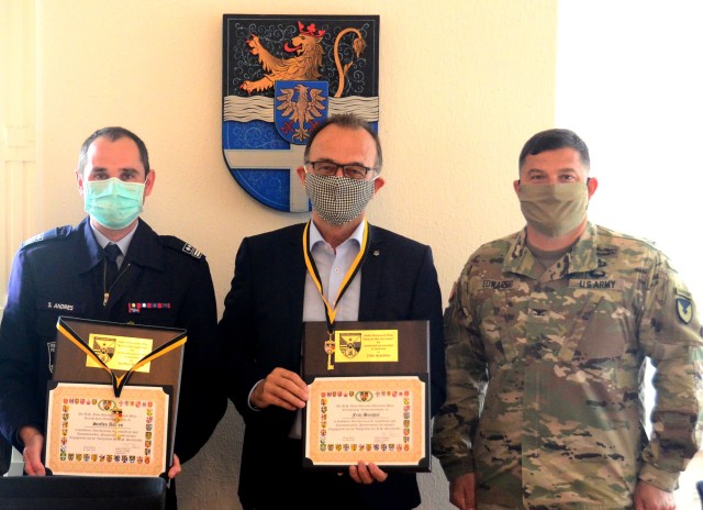 Steffen Andres, Lingenfeld Fire Chief, left, and Dr. Fritz Brechtel, Germersheim County Commissioner, pose with Col. Jason Edwards, U.S. Army Garrison Rheinland-Pfalz commander, after Edwards presented Keys to the Garrison to the gentlemen in a...