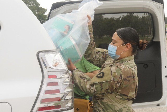 Army National Guard Spc. Jessenia Cano, an automated logistical specialist with the 449th Aviation Support Battalion, assigned to Joint Task Force 176, loads personal protective equipment into the vehicle of a medical provider in Austin, Texas,...
