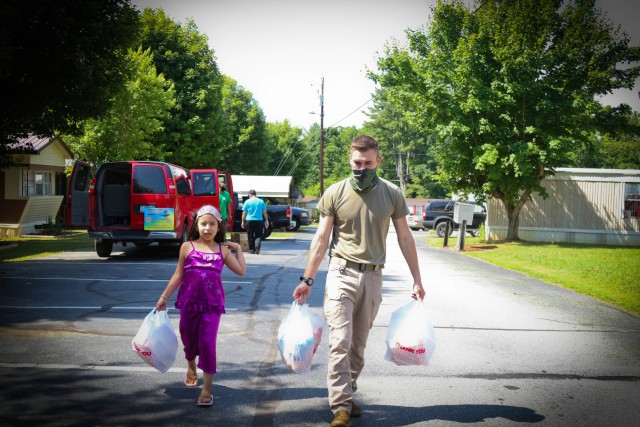 North Carolina Army National Guard Pvt. 1st Class Bennie Kinley (right), assigned to the 875th Engineer Company, helps carry breakfast meals, prepared at the Johnston Elementary School, to the children&#39;s houses of Buncombe County in Asheville,...