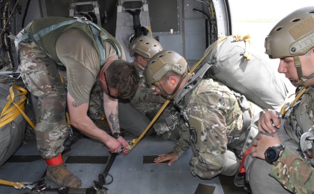 A jumpmaster hooks the static line of a 1st Bn (Abn), 509th Inf Reg paratrooper into a D-ring and onto the floor of a UH-60 Black Hawk helicopter July 1 at the JRTC and Fort Polk Geronimo Drop Zone.