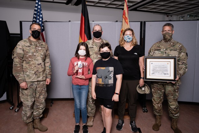 WIESBADEN, Germany - Lt. Col. Norman Hodges and Kerrie Hodges receive their award for Family Volunteer of the Year with their children June 30 during a Facebook live virtual ceremony at U.S. Army Garrison Wiesbaden Army Community Service....