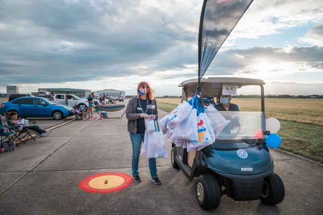 WIESBADEN, Germany - The USO staff utilizes the airfield’s golf carts to distribute 1,000 food and goodie bags to spectators July 4, 2020, at Wiesbaden Army Airfield. Larger bags were given as prizes to the first 75 cars set up with patriotic...