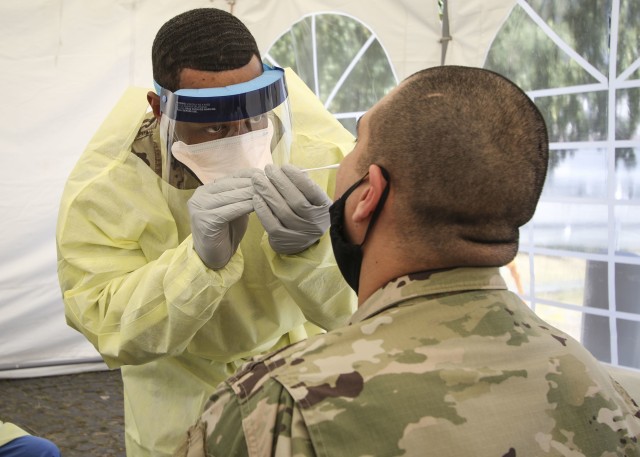 A combat medic at Wiesbaden Army Health Clinic, swabs a patient for COVID-19 testing, June 12.