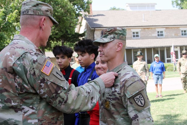 Maj. Gen. Kenneth Kamper, Fires Center of Excellence (FCoE) and Fort Sill commanding general, pins the Legion of Merit on FCoE and Fort Sill Command Sgt. Maj. John Foley as his wife, Dr. Ella Foley, left, and the couple’s two sons look on. Foley...
