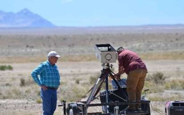 Kevin Gill (left) and Johnny Gallegos (right), DPG scientific technical photographers, keep their distance from one another while setting up high speed cameras prior to launch of the missile system. Photo by Becki Bryant, Dugway Public Affairs