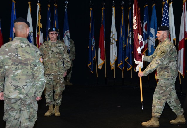 In order to maintain social distancing standards, Command Sgt. Maj. Matthew Baller simulates handing the Regional Health Command Europe flag to Lt. Gen. Christopher Cavoli, the U.S. Army Europe commanding general.  Cavoli was the presiding officer...