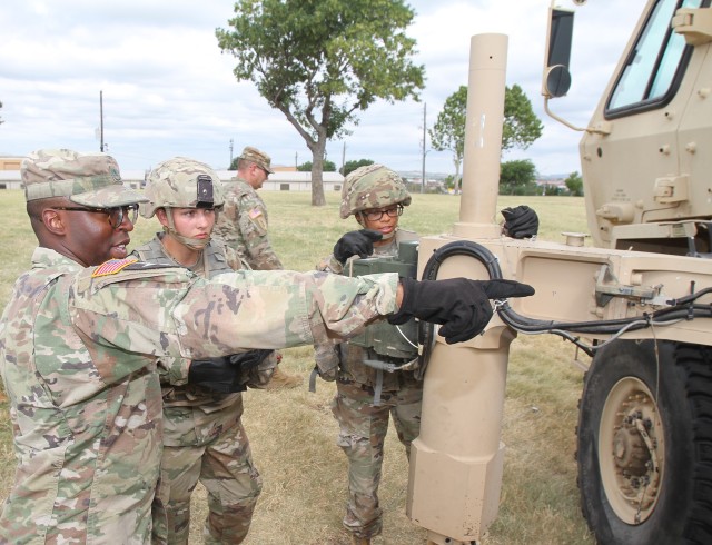 Staff Sgt. Jacory Evans, a 13R Field Artillery Firefinder Radar Operator instructor at Fort Sill, Oklahoma, directs Pvt. Destiny Cole on proper procedures to stow an outrigger arm on the TPQ-53 Counterfire Target Acquisition Radar. 13R Soldiers...