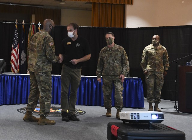 U.S. Army Training Center and Fort Jackson Commander Brig. Gen. Milford ‘Beags’ Beagle Jr., hands Nathan Clinebelle, a visual information specialist with
...