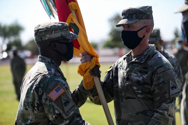 FORT BLISS, Texas -- Col. Jabari Miller, commander of 3rd Armored Brigade Combat Team "Bulldog", 1st Armored Division hands the Bulldog Brigade Colors to Command Sgt. Maj. Derrick Braud, senior enlisted advisor for 3rd ABCT, 1st AD  at the Bulldog Brigade Change of Command Ceremony at Fort Bliss, Texas, July 9. (U.S. Army photo by Staff Sgt. Alon Humphrey)