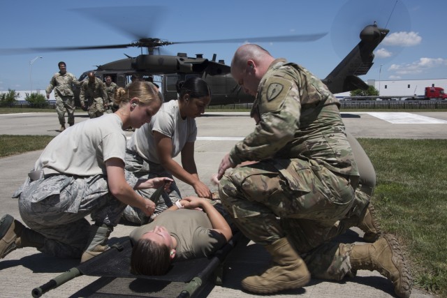 Airmen and Soldiers from the Indiana National Guard prepare to load a patient into a UH-60 Black Hawk helicopter during a medical transport exercise at the Johnson County Armory, Franklin, July 2, 2020. During the exercise, members practiced...