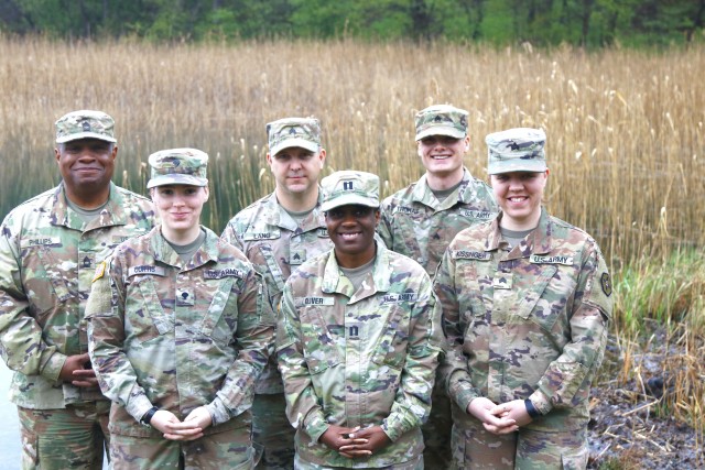 Drawsko Pomorskie mayor cell team is posing together by the lake outside of base camp.  Led by Capt. Jocelynn Oliver, this team of seven is part of the 652nd Regional Support Group, a U.S. Army Reserve unit out of Helena, Montana. The RSG is responsible for providing life-sustaining operations on a military base. This includes every facet of Soldier life, from billeting to laundry and the dining facility.