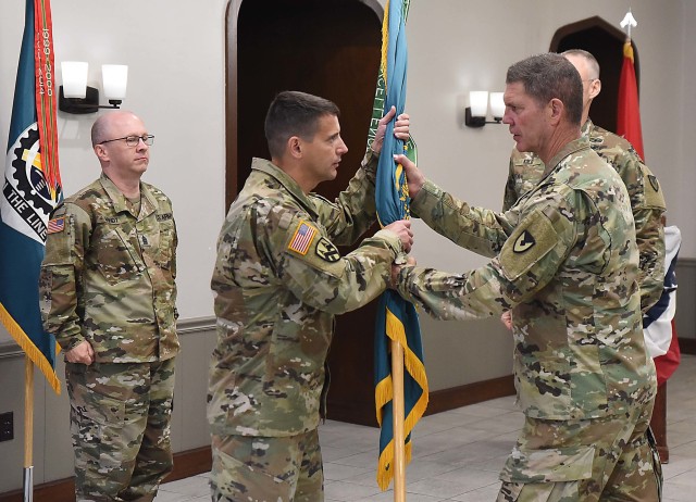 Col. Michael Clark, incoming commander, LOGCAP Support Brigade, receives the unit colors during a change of command ceremony July 10 in Heritage Hall, Rock Island Arsenal, Illinois. (Photo by Jon Micheal Connor, ASC Public Affairs)